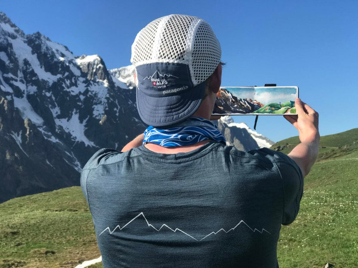 Max Romey wearing RTA gear and holding a painting above Bertone hut near Courmayeur, Ital. (Photo: Jordyn Milbrath)