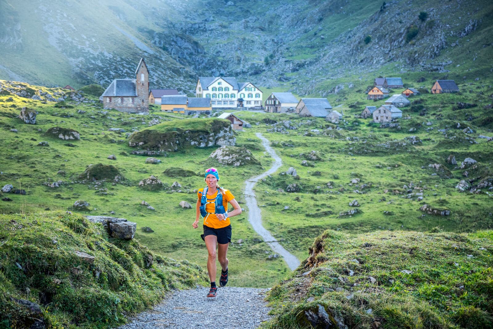 Kim Strom trail running through the old dairy farm village of Meglisalp, in the Alpstein mountain region of eastern Switzerland.