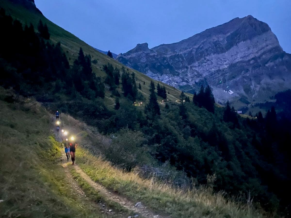 Runners with headlights near treeline