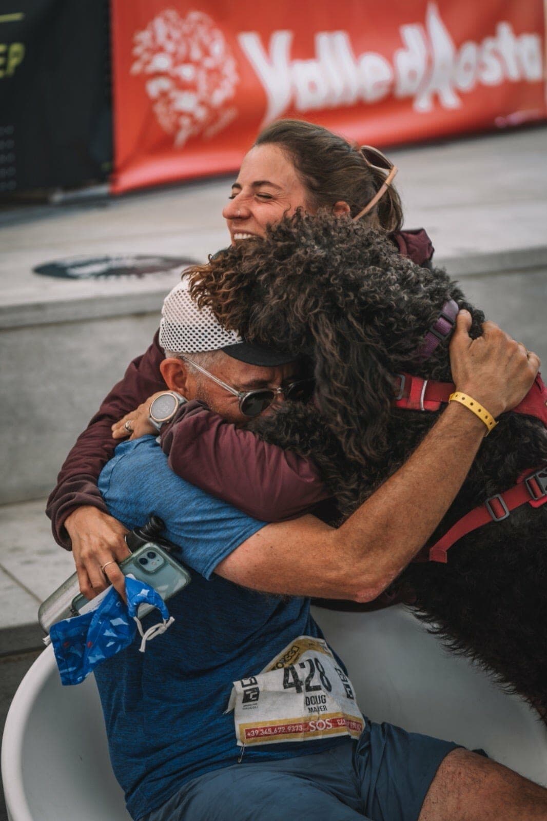 Doug Mayer at the finish of Tor des Geants with his dog and friend Hillary Gerardi.