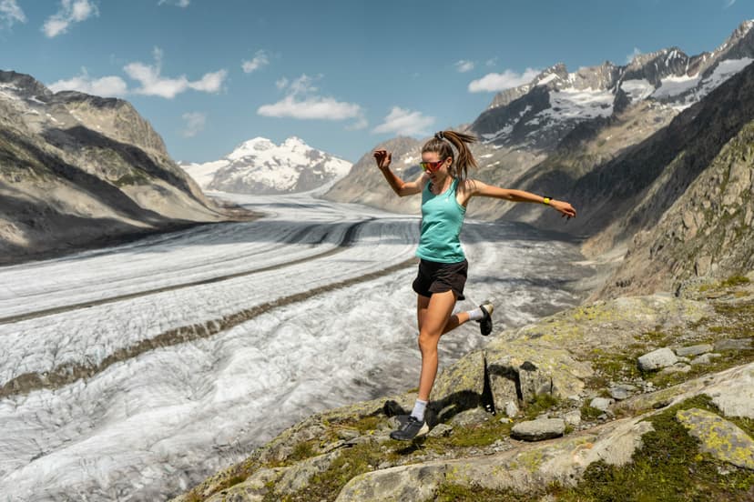 A female runner runs in shorts alongside the Aletsch glacier, Switzerland.