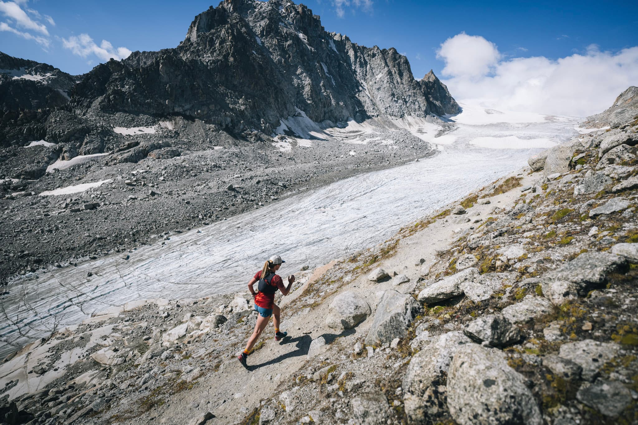 runner above glacier on single trail