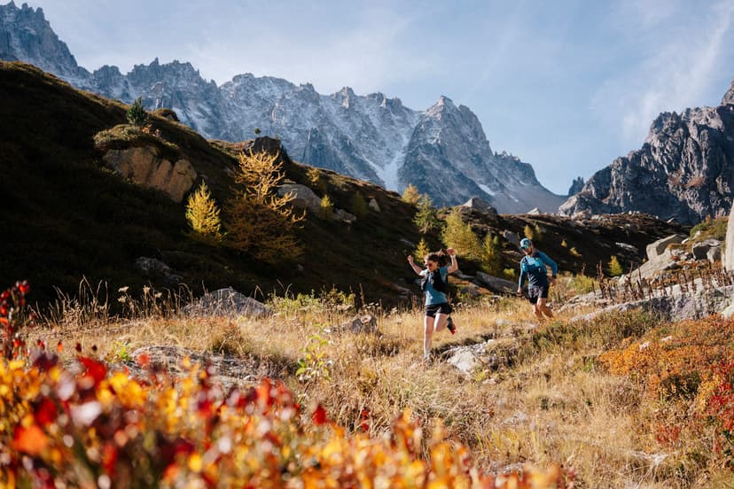 2 runner run down hill in grassy single track