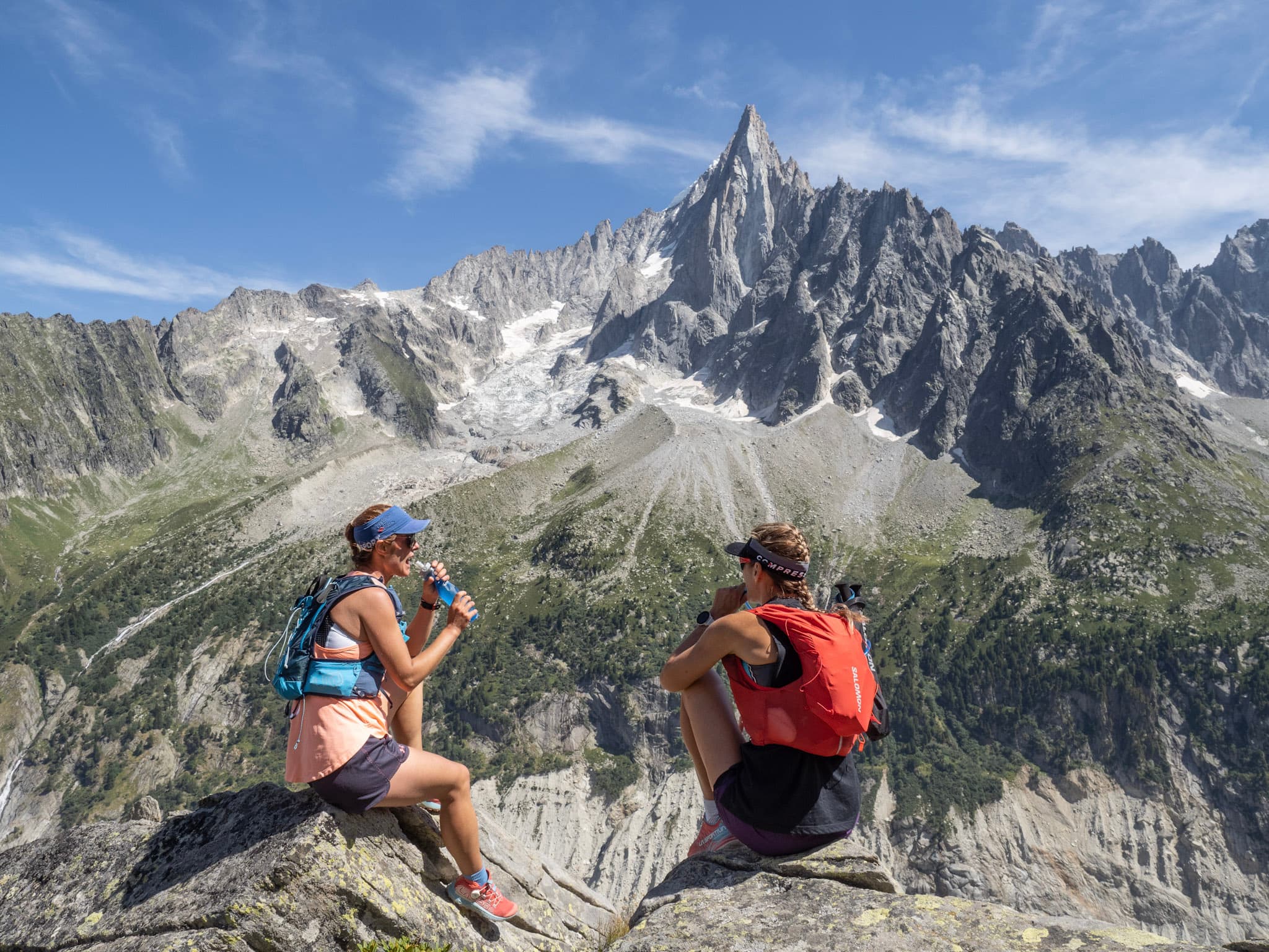 to runners, stopped to have a snack with pointy Rocky Mountains behind