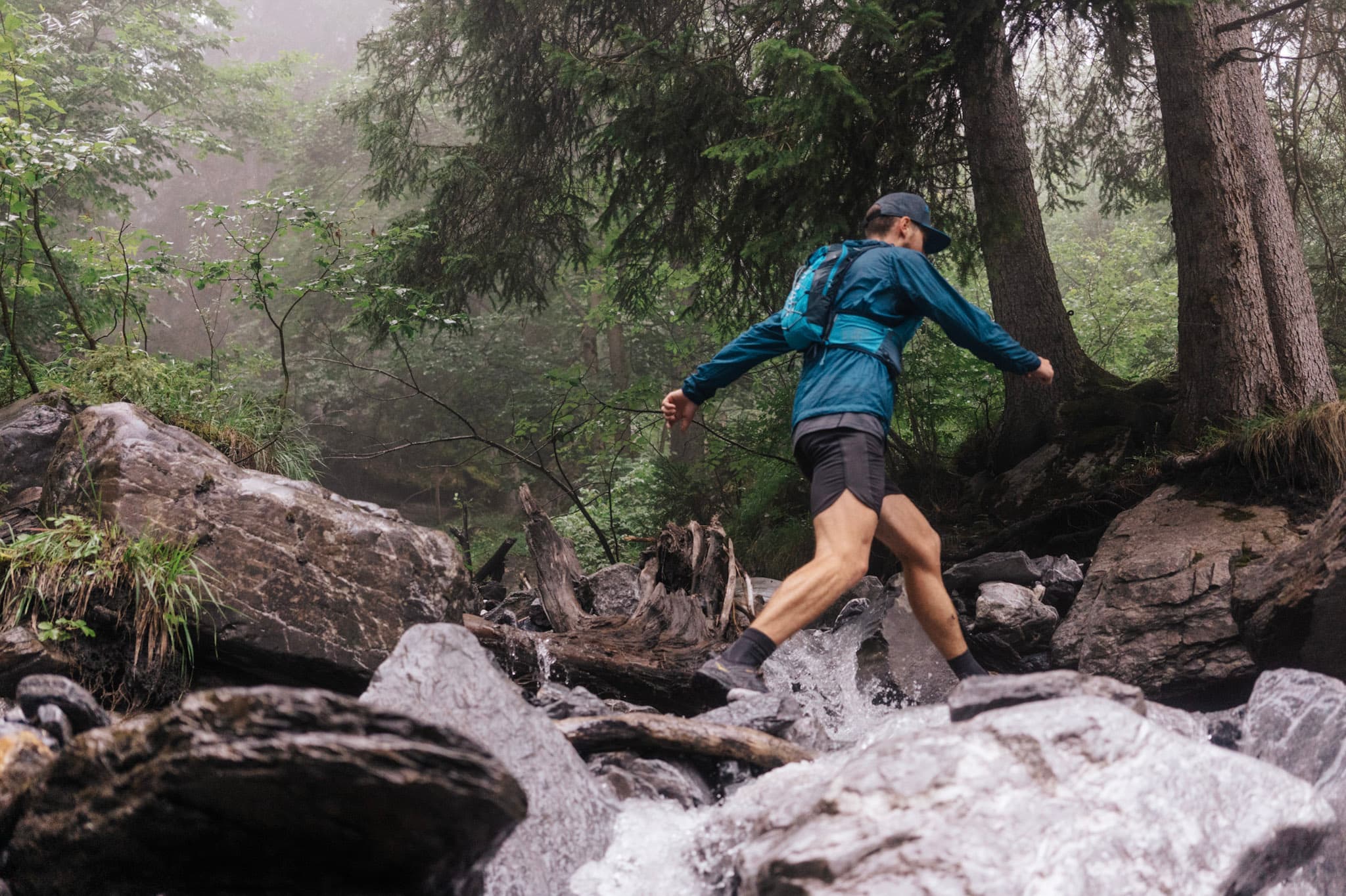 one runner crosses stream jumping between rocks