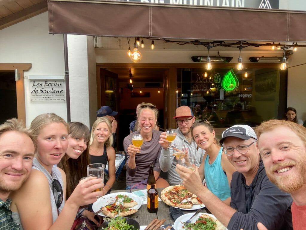 Nine people eating pizza and drinking beer at a terrace