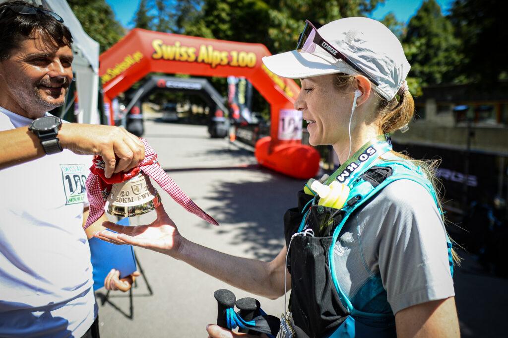 Jakob Herrmann greets the 2022 winner of the 50km race with a Swiss bell