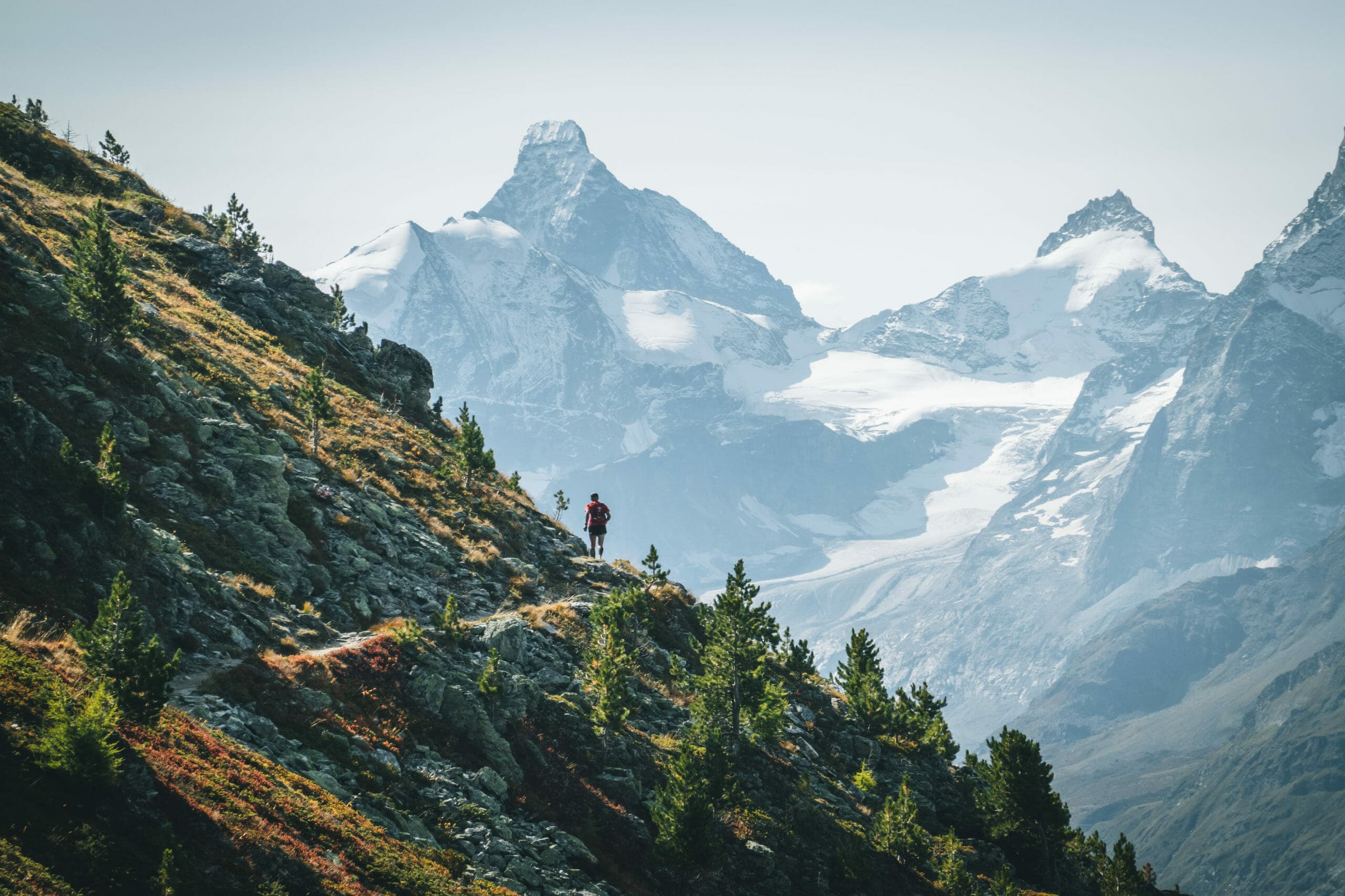 Trailrunner on single track with white peaks and glacier at the back