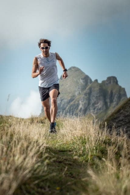 Urs Baumgartner in shorts and with sunglasses on a grassy trail