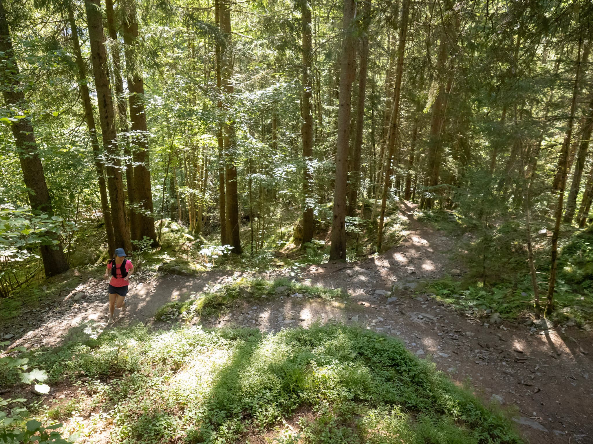 Runner running up hill in forest