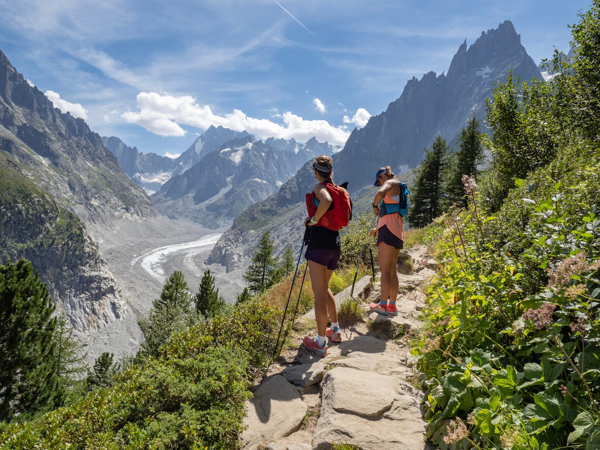 Two runners Stop on Rocky Trail to look at the glacier at the mountains