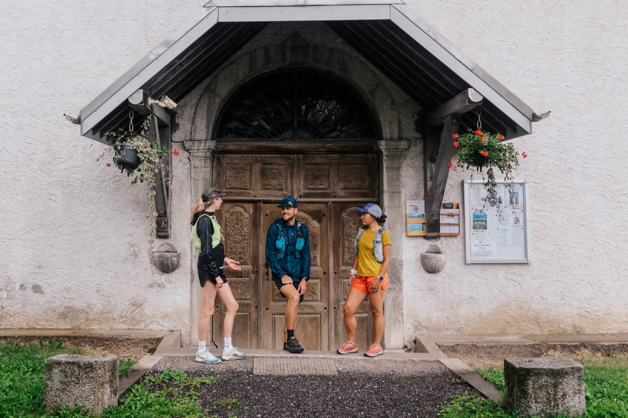 3 runners stood outside old church