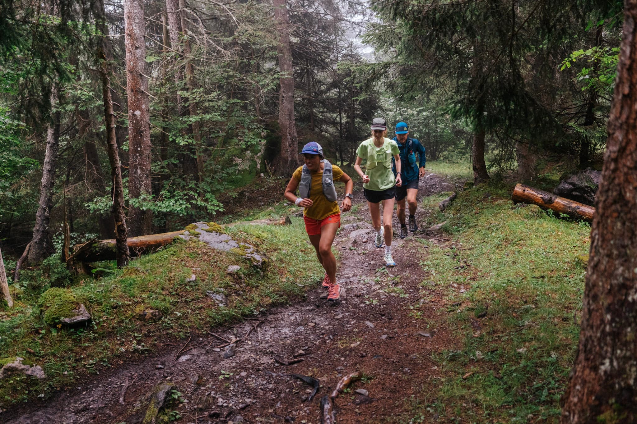 3 runner run up trail in forest