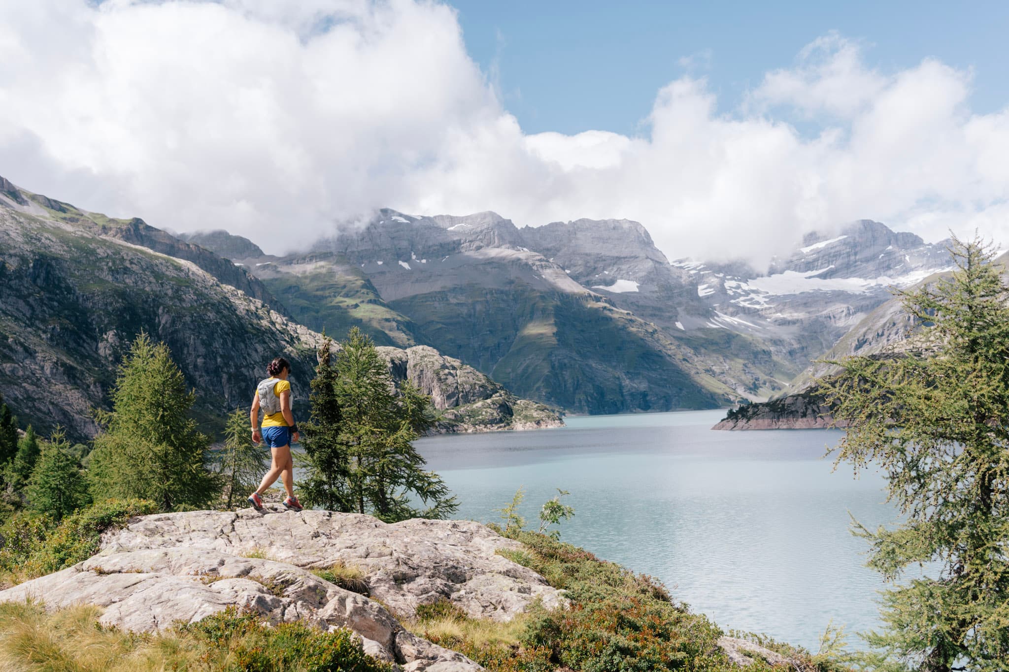 Runner walks on rocks above lake