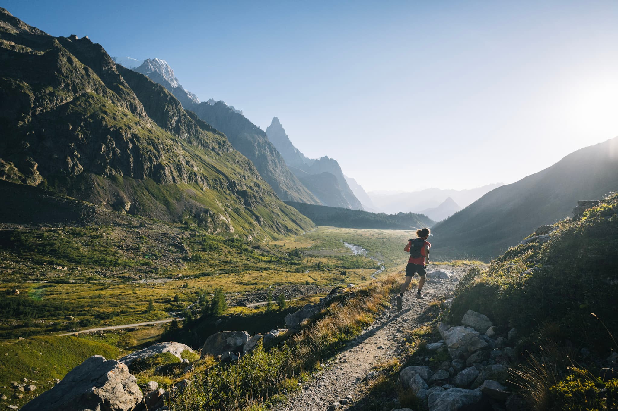 Runner on flat single track with mountains and morning light