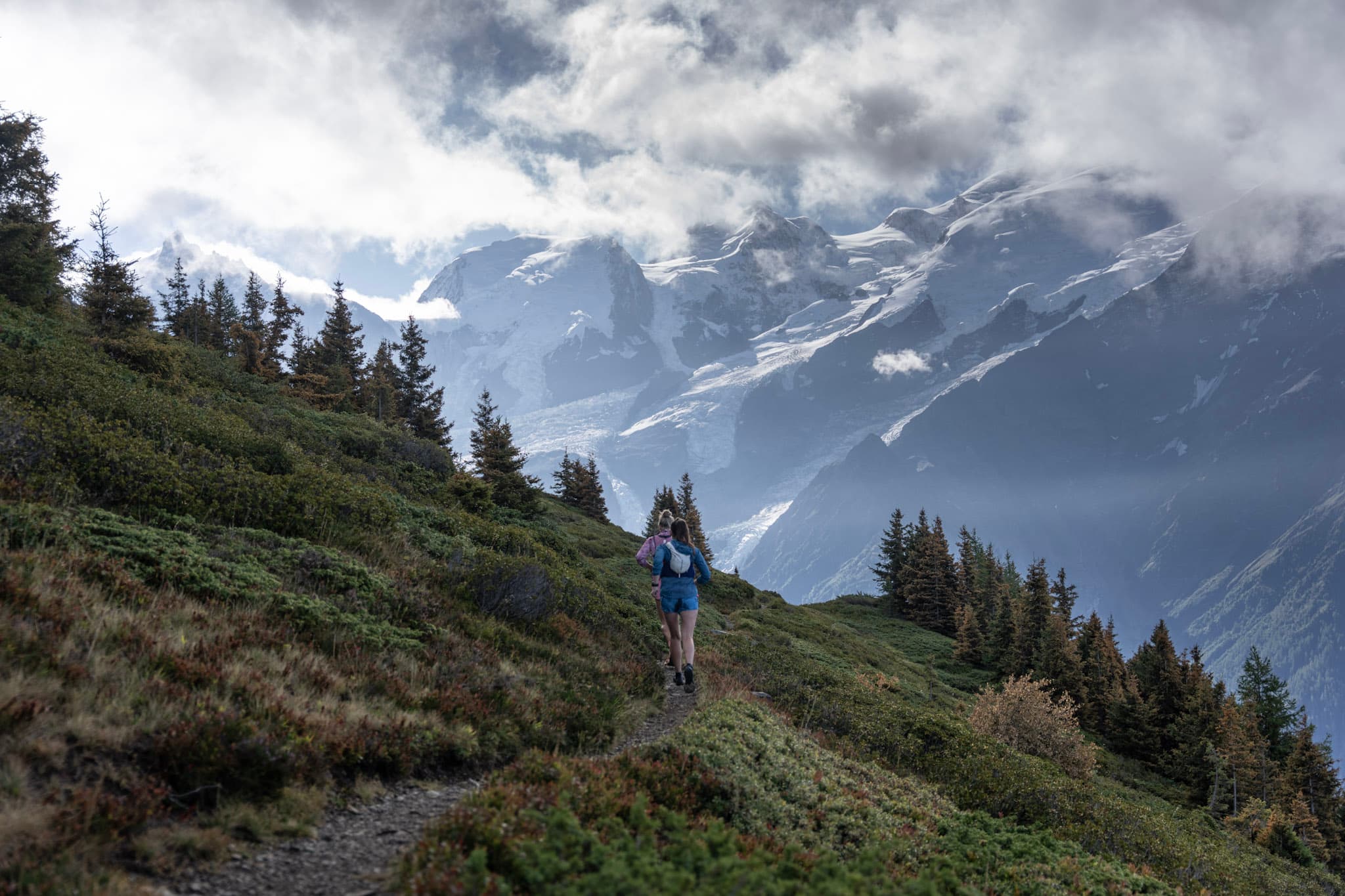 1 runner on single track with cloudy aline mountains in background