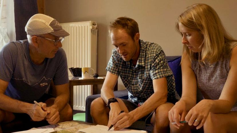 Mike, Steph and Doug sitting on couches and working with maps