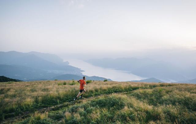 A trail runner running down towards Lago Maggiore