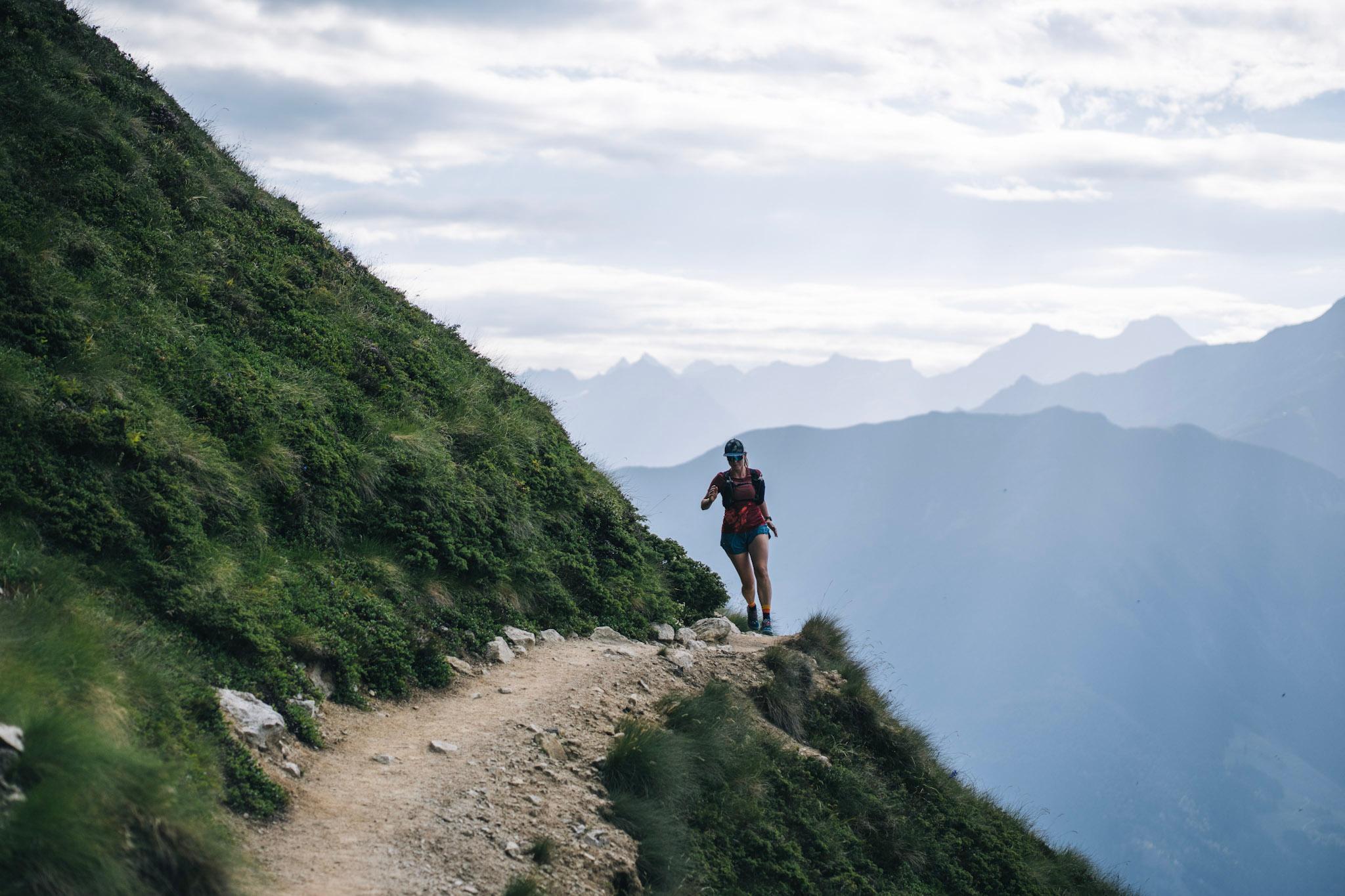 Runner on traversing high mountain single trail