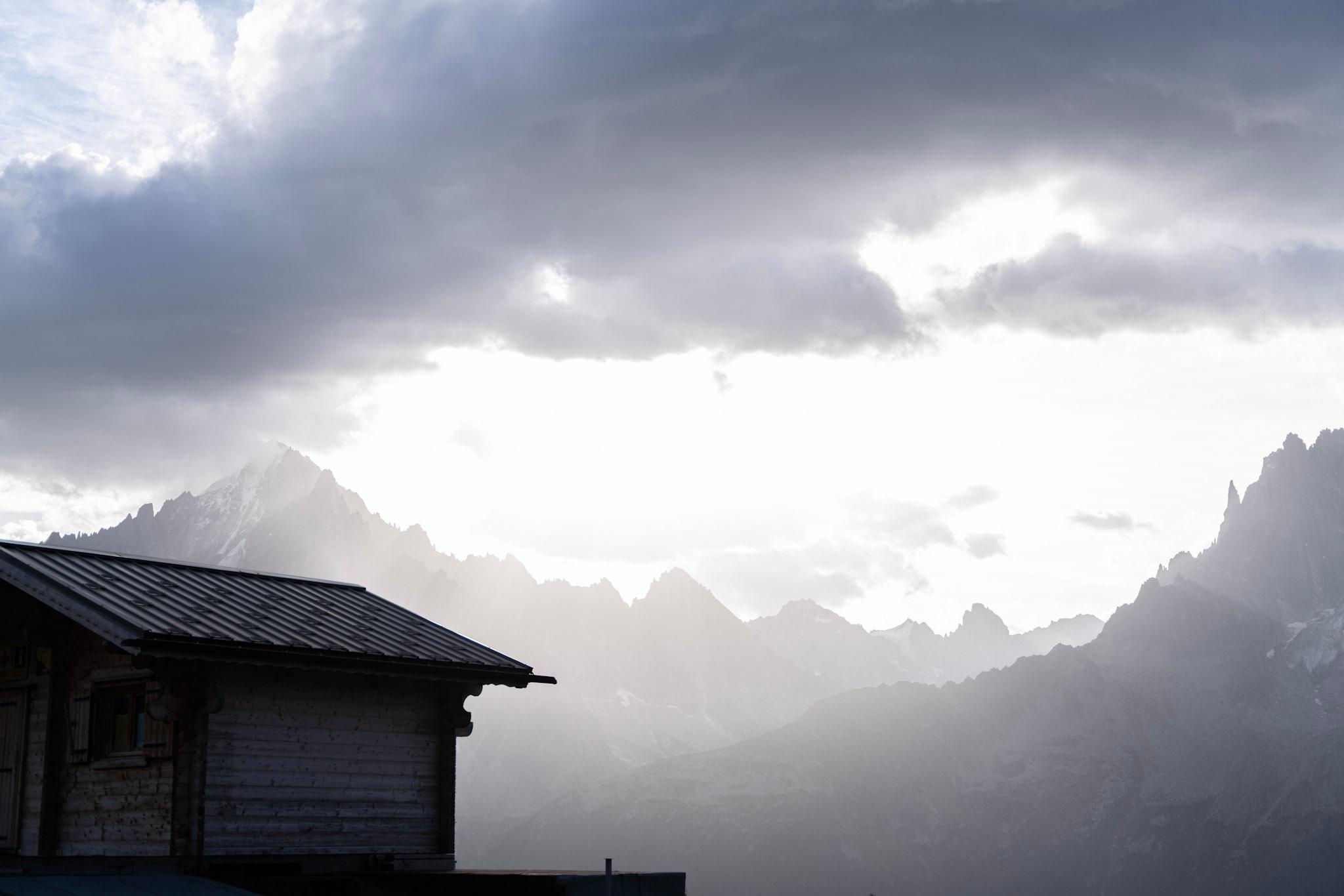 Mountain refuge with mountains in background with clouds and morning light