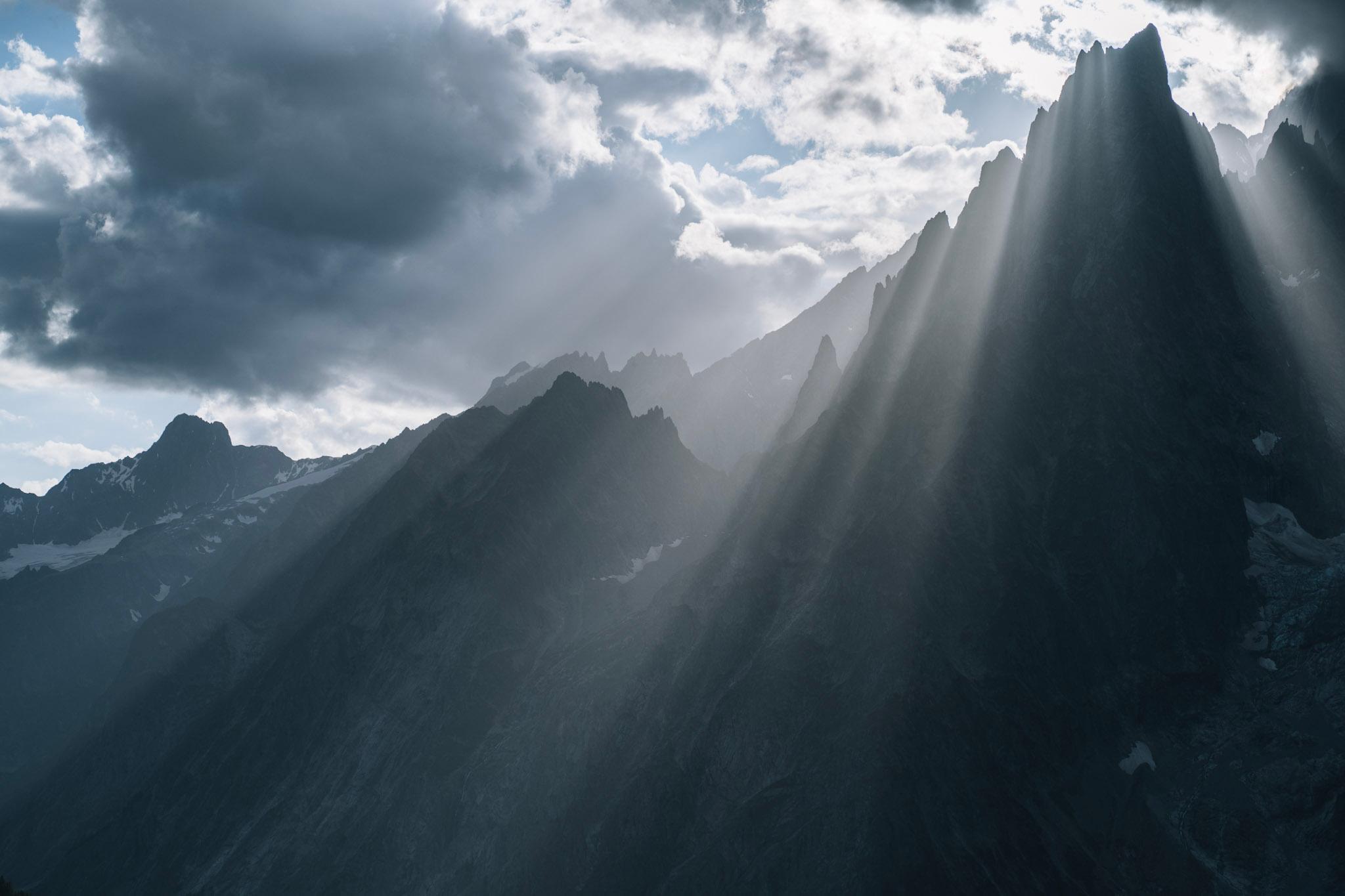 Sun rays shine through spiky Rocky Mountains