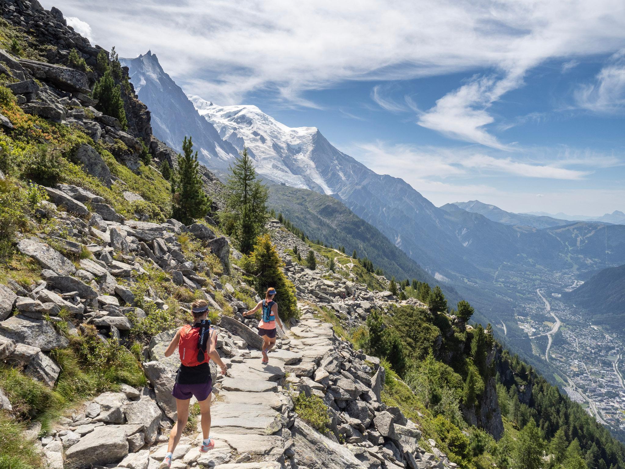 to runners run, downhill with mountains above and valley beneath