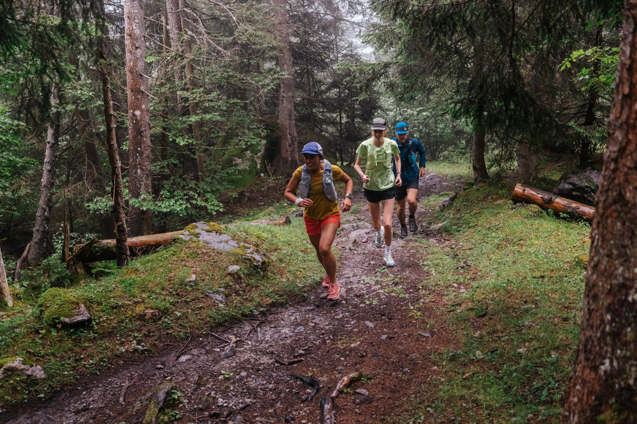 3 runner run up trail in forest