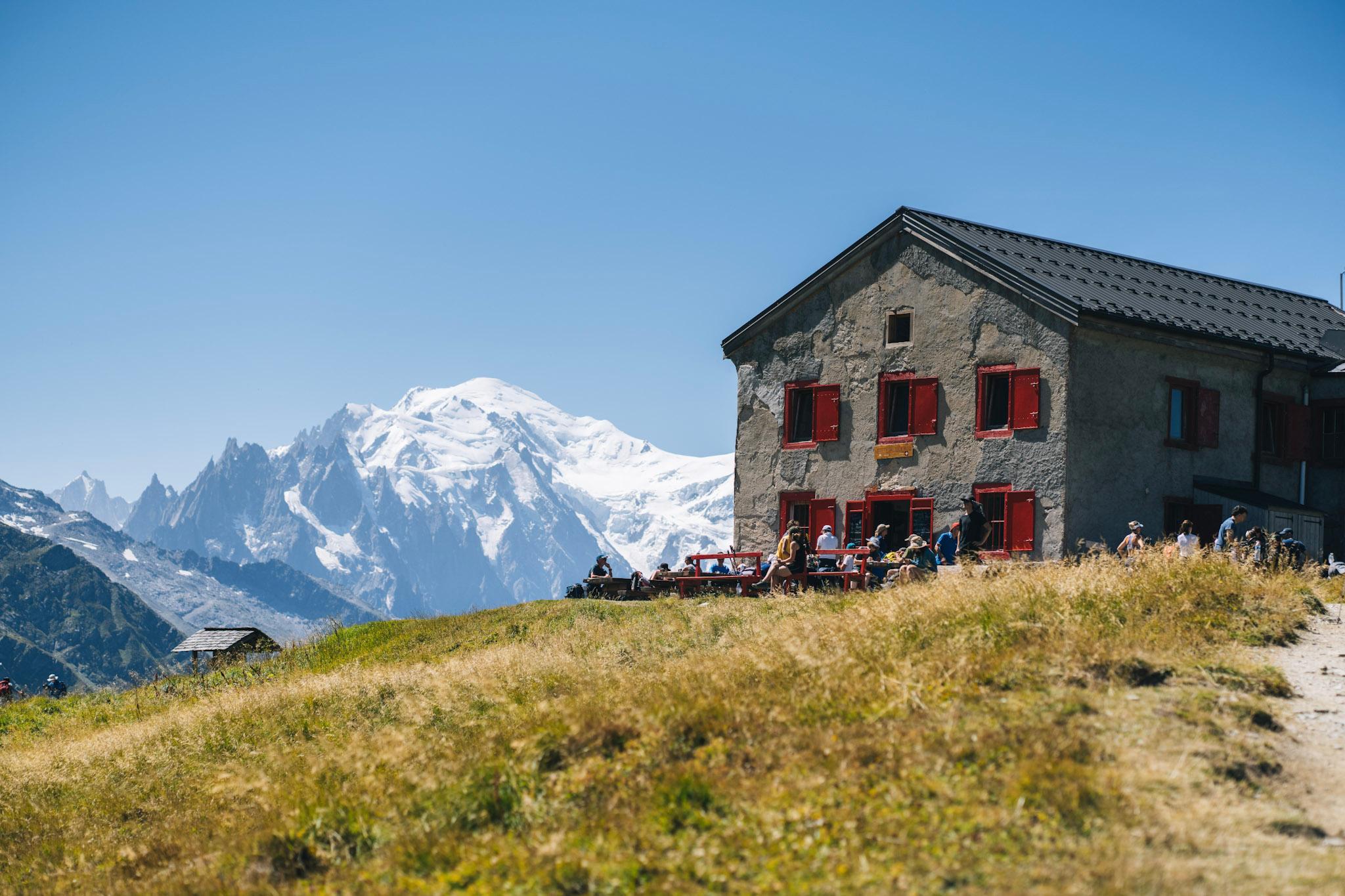 mountain refuge with red shutter with Mont Blanc in the distance