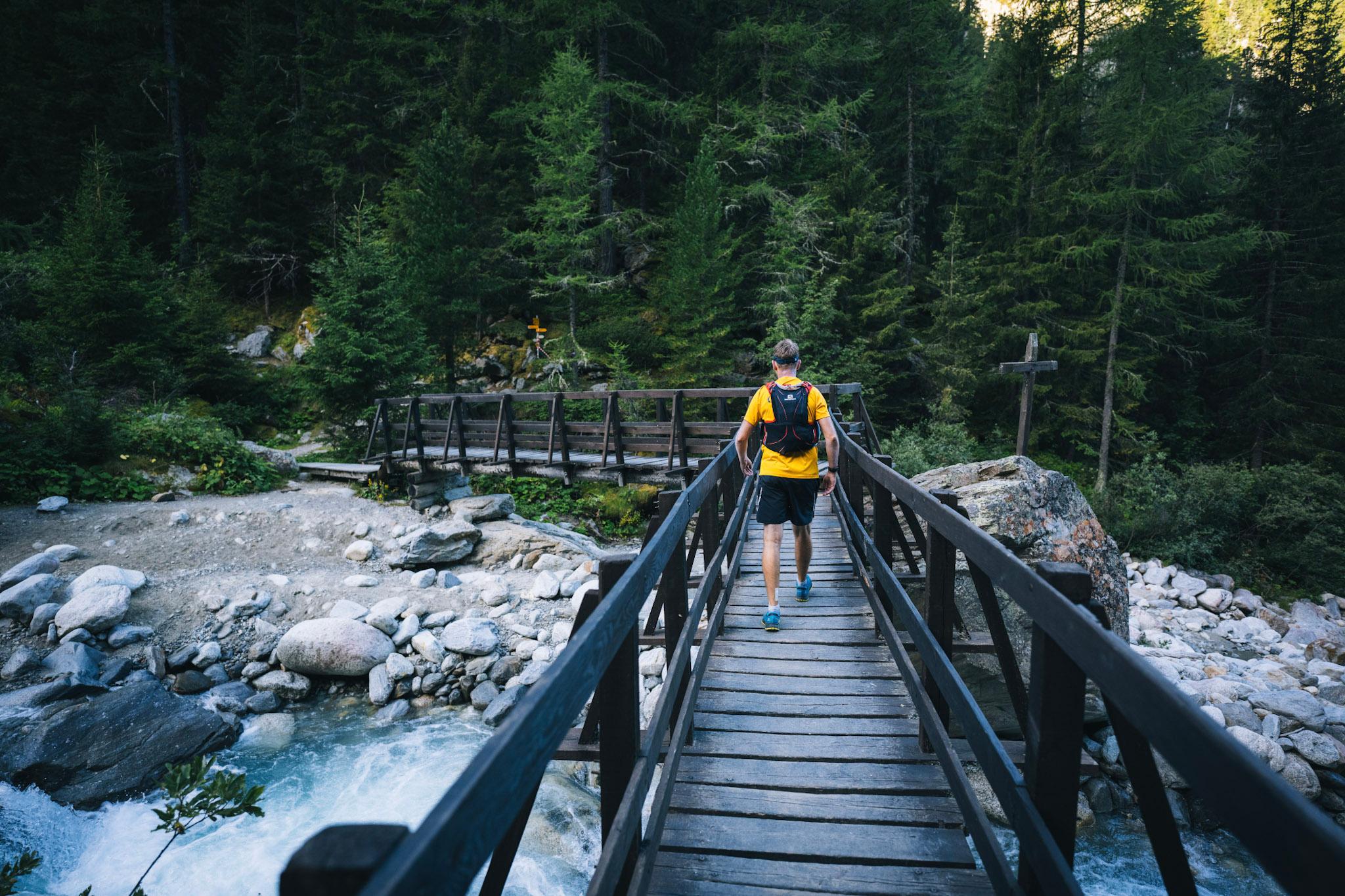 runner walking across a bridge over a river