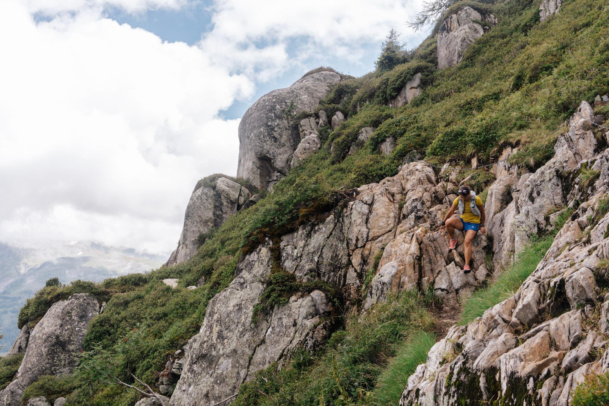 Runner scrambles down rocky section on trail