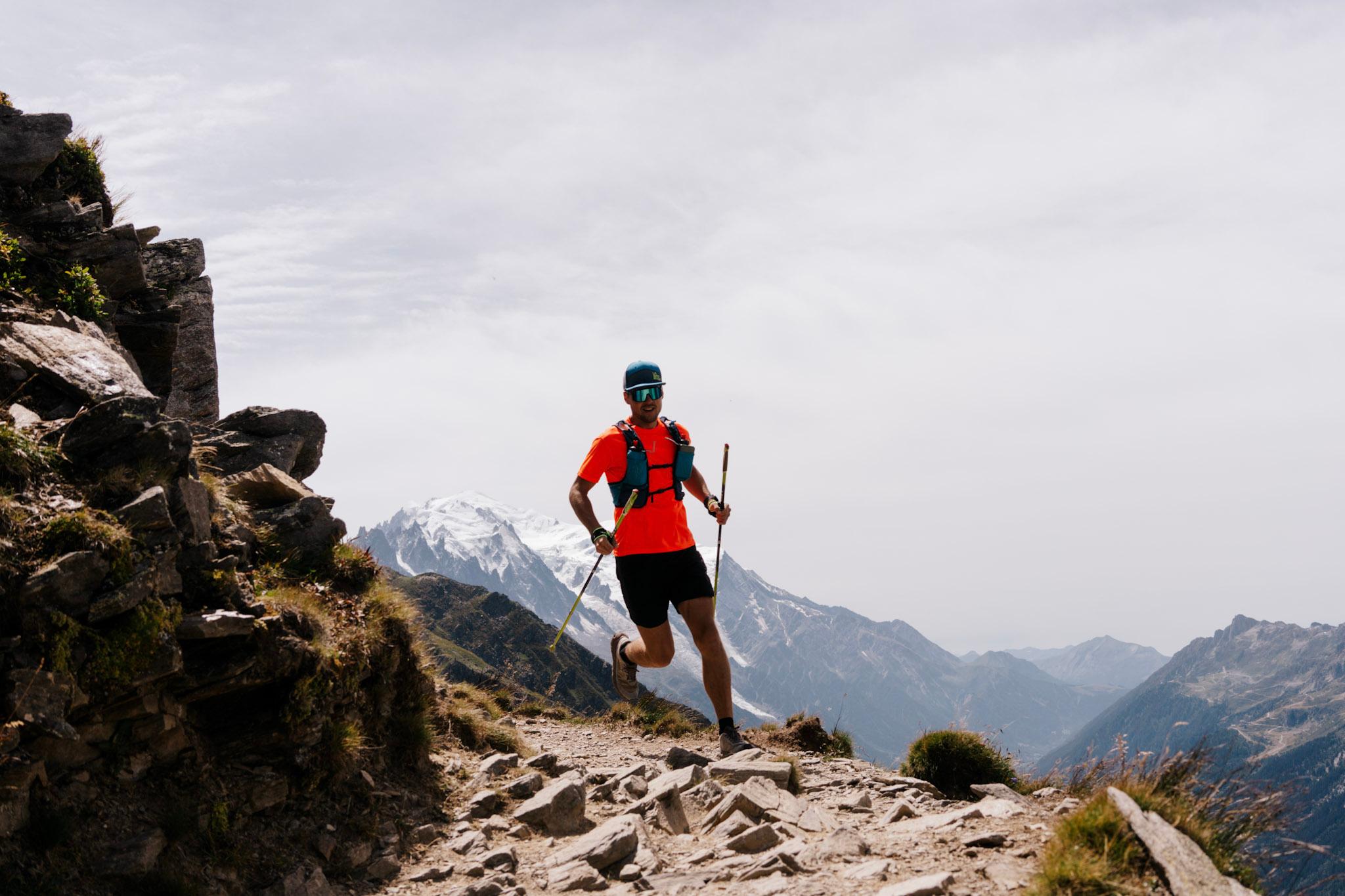 Runner runs around corner on high mountain rocky trail