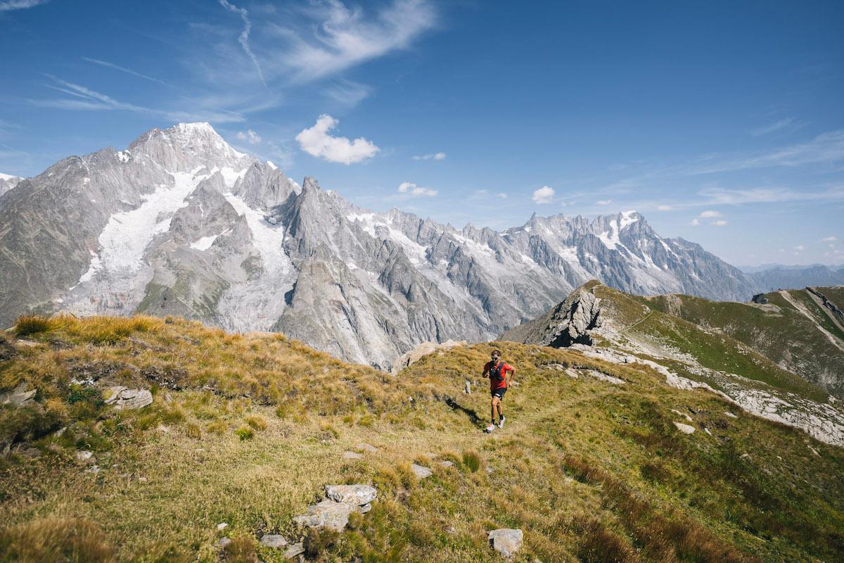 A trail runner on a ridge in Aosta valley, Italy, with Mont Blanc in the background