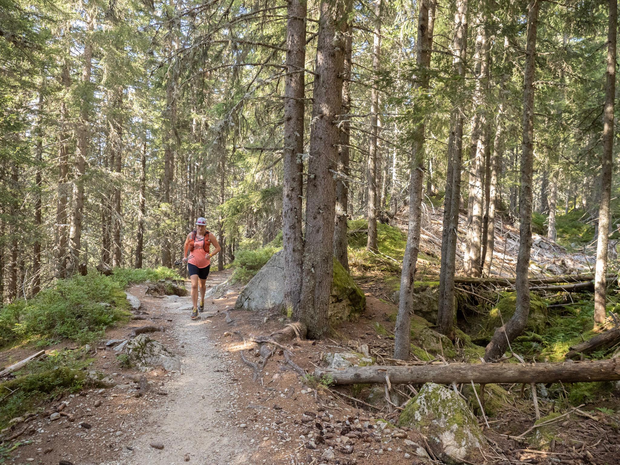 Woman runs along forest trail