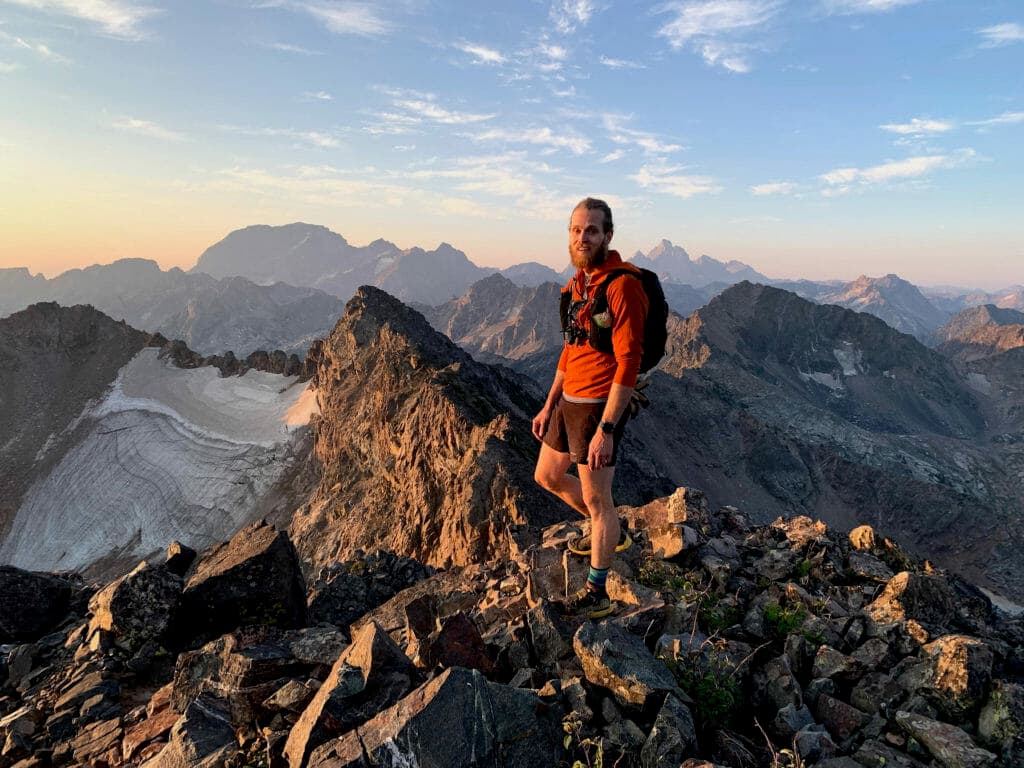 A trail runner on a rocky peak in the mountains