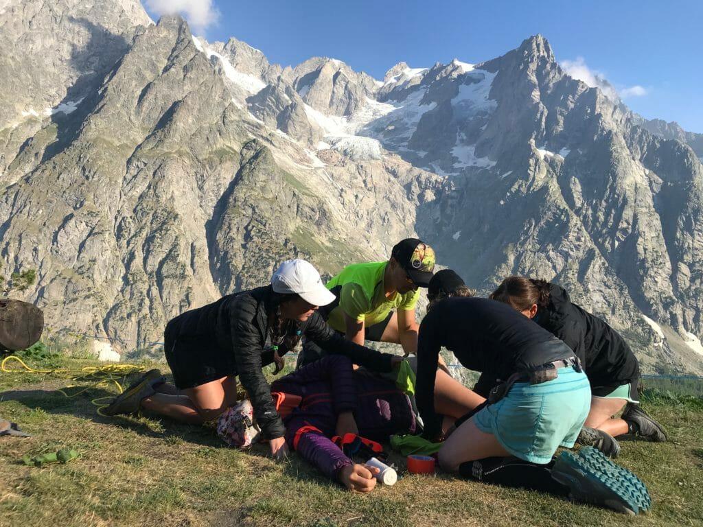 A team of volunteers surround an injured person in a training drill in the Alps. 