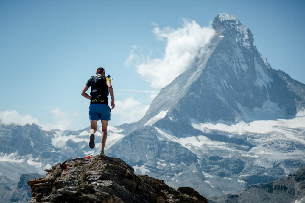 A racer moves across a narrow ridge, just before the descent to Zermatt, the Matterhorn in the background