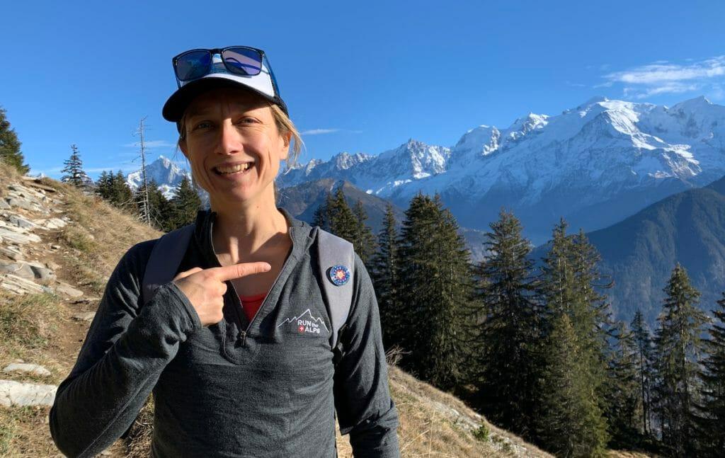 Run the Alps Guide Emily Geldard with her IML badge in front of the Mont Blanc massif