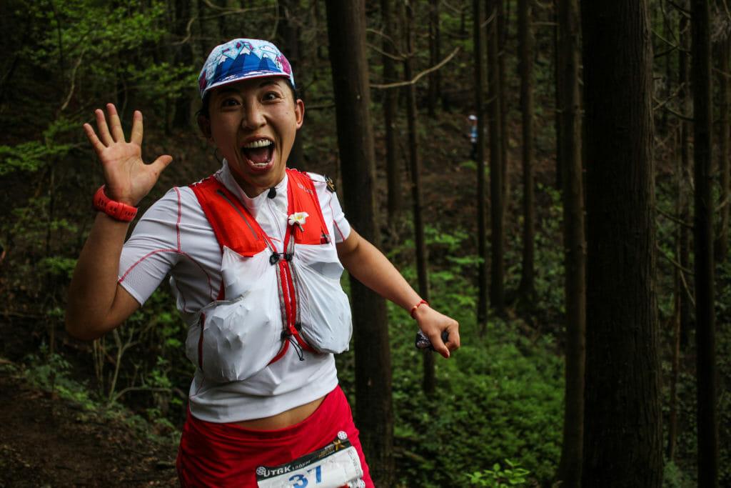 A trail runner, running and smiling