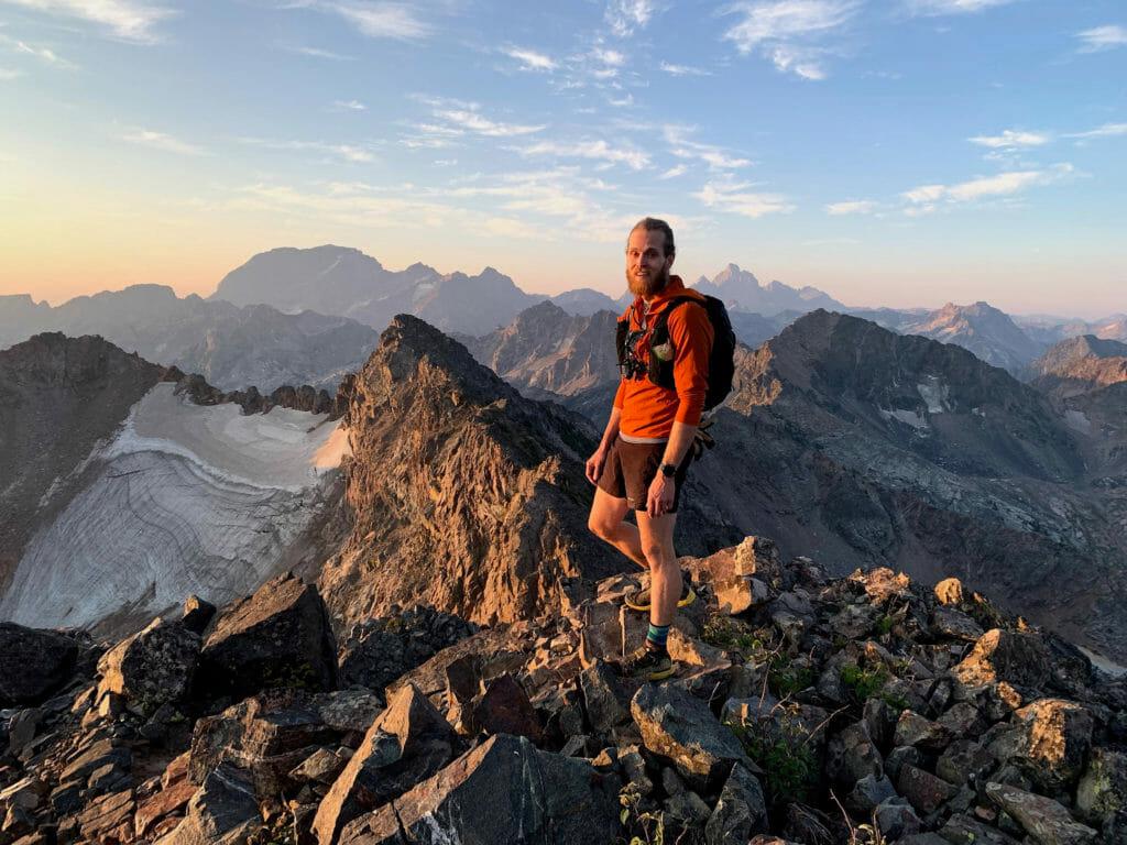 A trail runner on a rocky peak in the mountains
