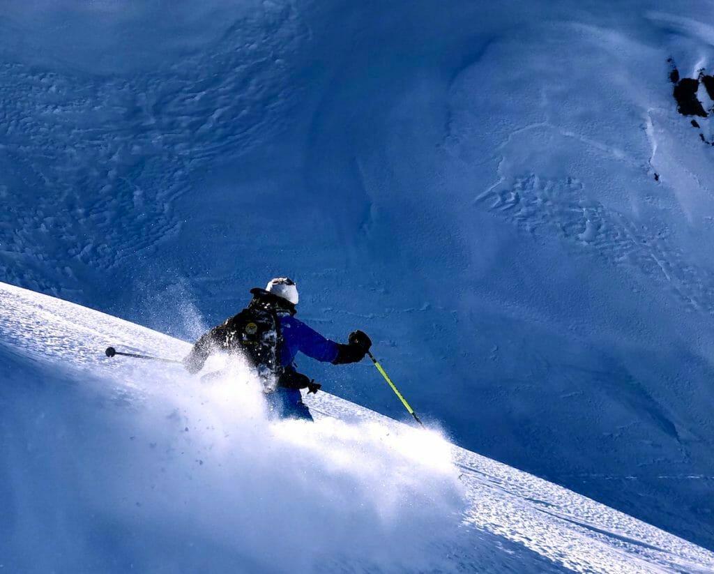 Giles skiing in powder on a steep slope