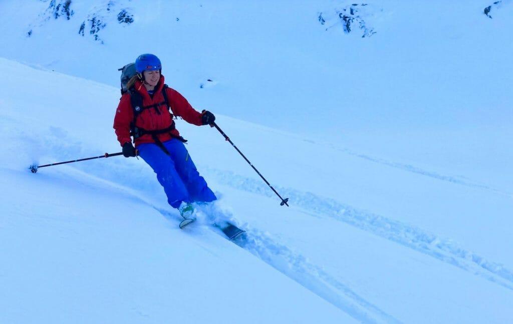 Becki with blue helmet and pants and red jacket skiing in Bérard Valley Chamonix