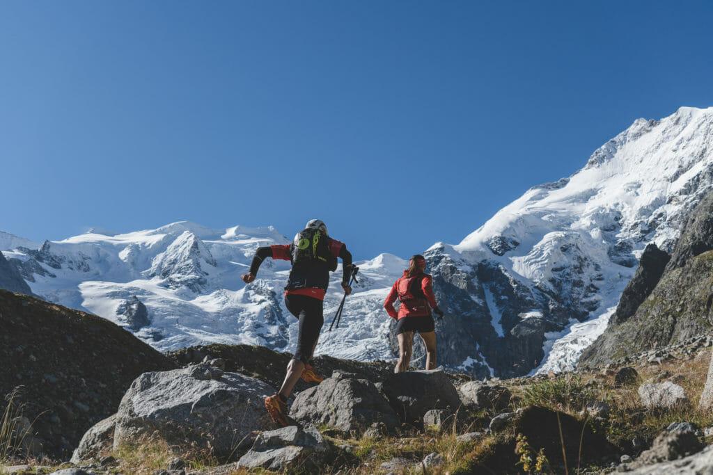 Trail runners from the back with Piz Bernina and Piz Palü
