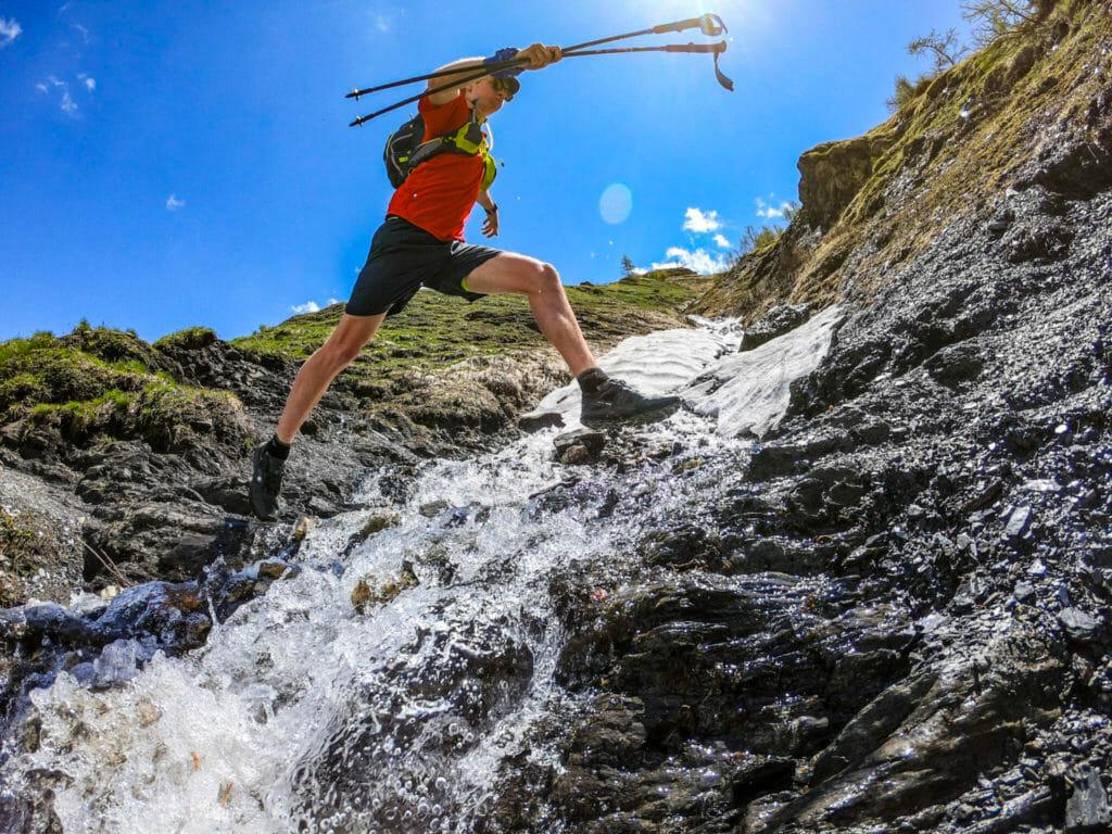 stream crossing jump prominently displaying trail running shoes