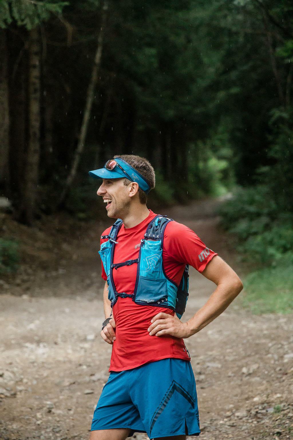 Laughing Sam Hill with red shirt and blue viser, shorts and trail run vest