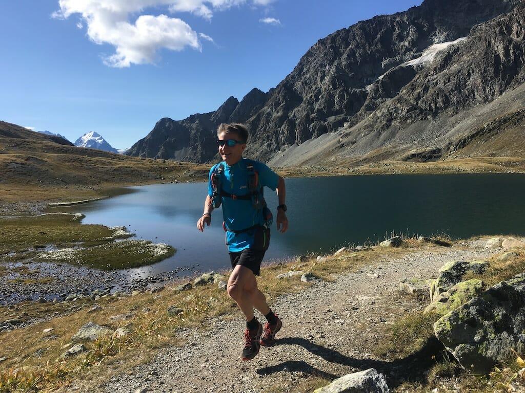 Roberto Rivola running along a mountain lake in Engadine
