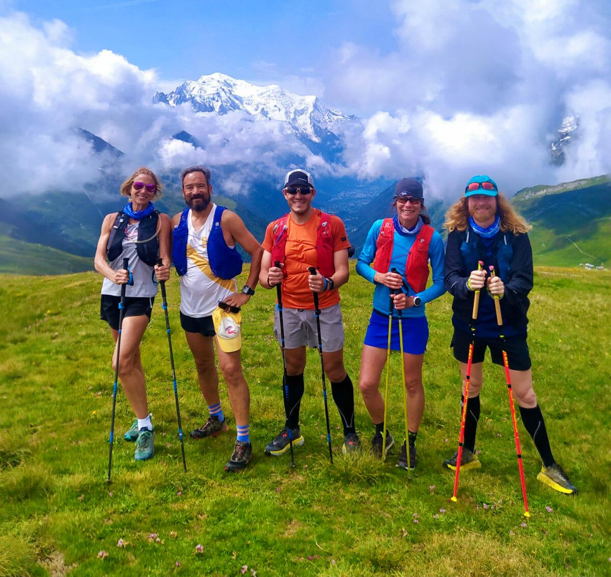 Five trail runners stop and posed with the Mont Blanc Massif at the back