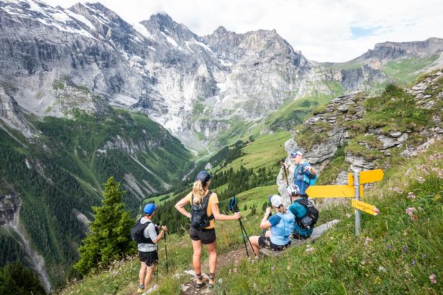 A group of trail runners in the Bernese Oberland at some sign posts.