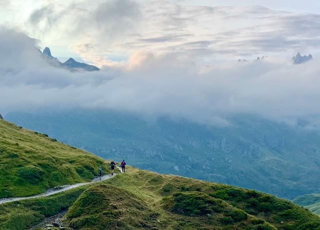 Three runners on single track in the Aiguilles Rouges mountains in the Alps