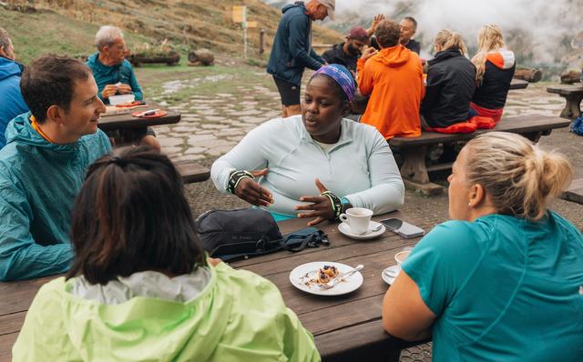 A group of trail runners stopping for coffee at an Alpine hut