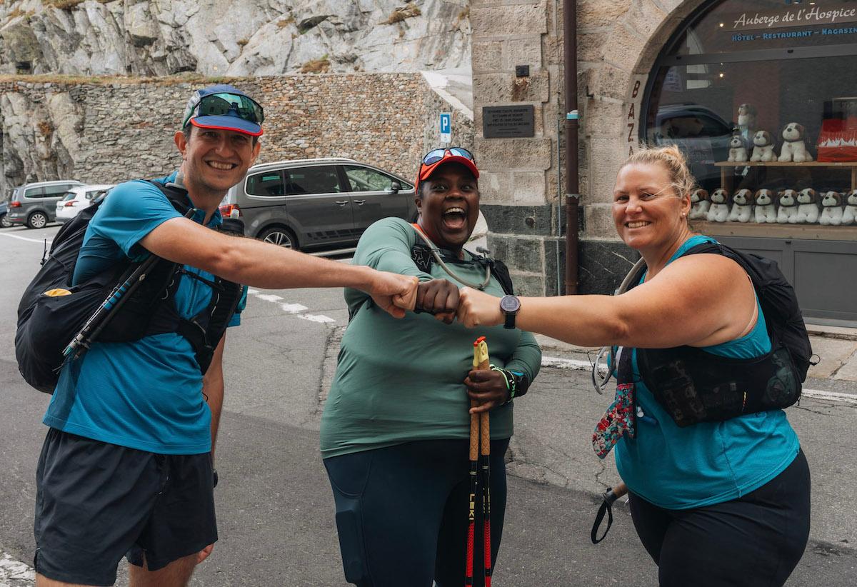 Mirna Valerio celebrating getting to the top of the Swiss Alps pass with two Run the Alps team members